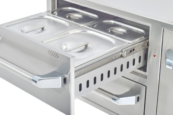 A warming drawer with a Drawer Slide and multiple compartments, each holding a metal container with lids, built into a counter.