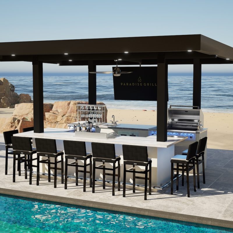 An image depicting a Monaco outdoor kitchen island featuring GSL-32 Professional Grill, CSL – 32 Cocktail Station, accompanied by accessories including a sink, TV, and stools under a clear blue sky, overlooking a calm sea.