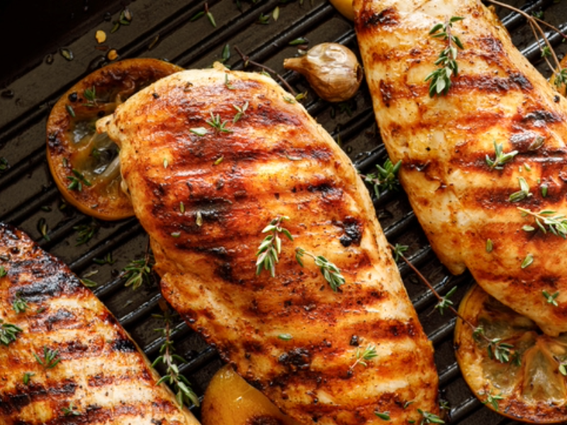 The photo depicts sizzling Chicken and Garlic on the Grill